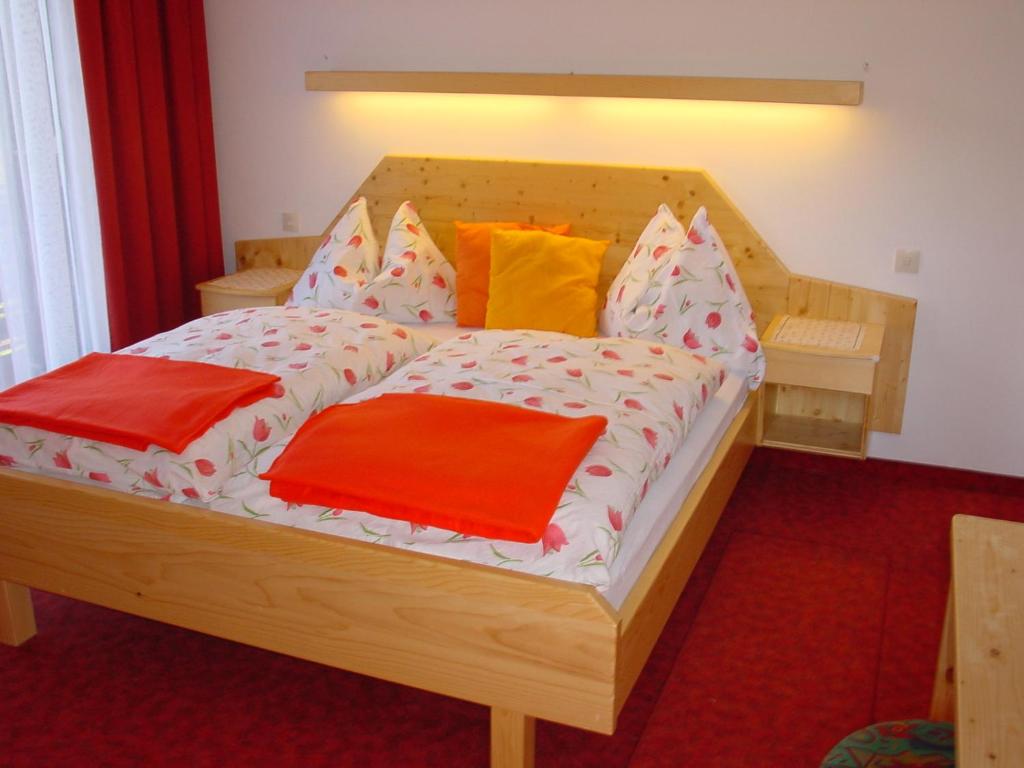 拉茨查赫·奥伯登弗Apartments Wrolich的一张带色彩缤纷枕头的木床