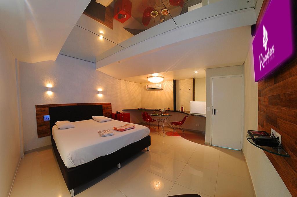 累西腓Rhodes Hotel Recife的一间酒店客房,配有一张床和一台电视