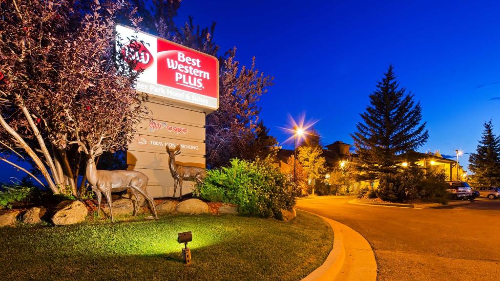 克雷格Best Western Plus Deer Park Hotel and Suites的前面有两座鹿雕像的餐厅的标志