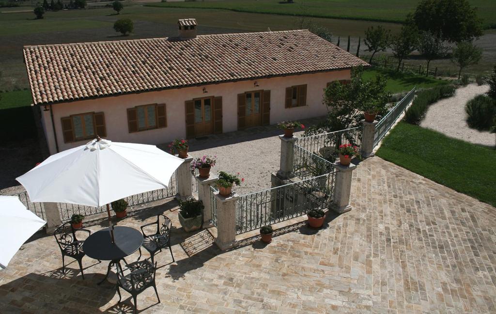 诺尔恰拉卡斯那迪奥帕克农家乐的一个带桌子和遮阳伞的庭院和一座房子