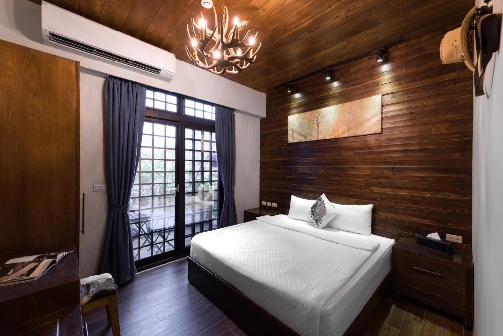 高雄高雄月缇主题套房的一间卧室设有一张床、一个窗户和一个吊灯。