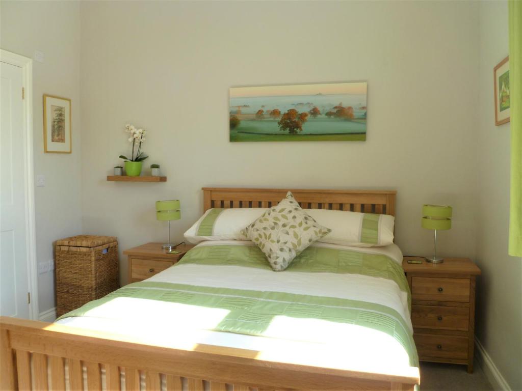 格拉斯顿伯里Chalice Lodge的一间卧室配有一张床、两个床头柜和两盏灯。