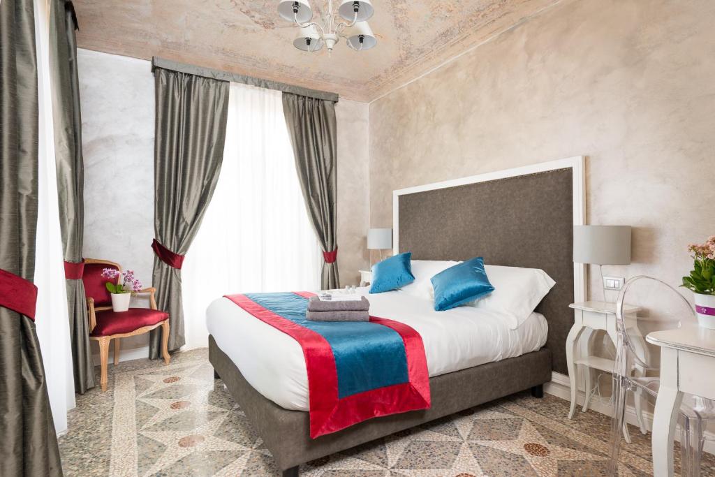 都灵塞利阿住宿加早餐旅馆的一间卧室配有一张带蓝色和红色枕头的大床