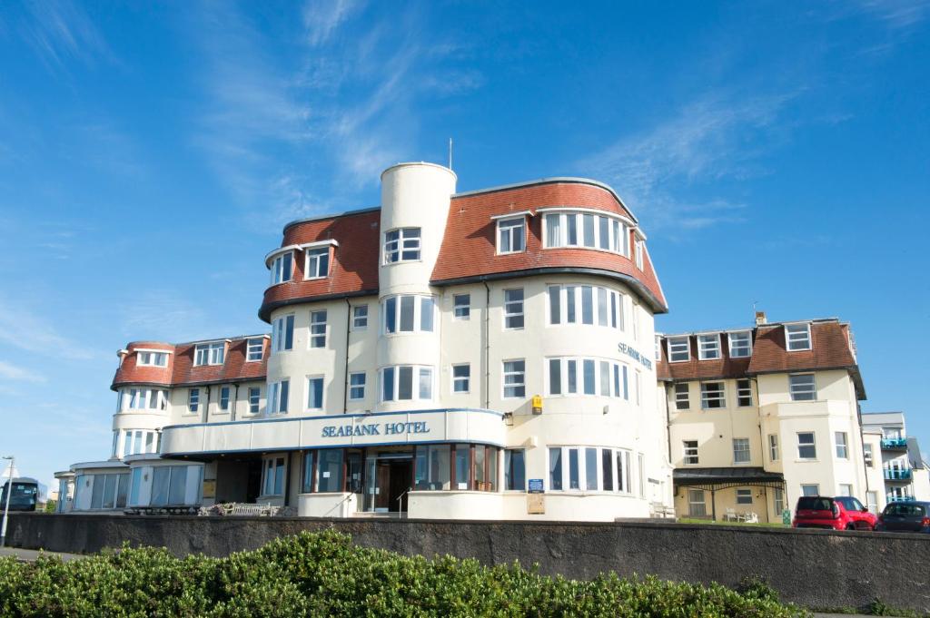 波斯考尔海畔酒店的一座白色的大建筑,有红色的屋顶