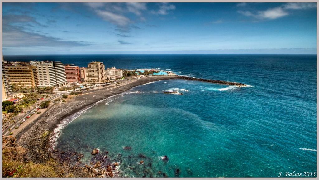 拉克鲁斯Apartamento Puerto de la Cruz的享有海滩的空中景色,设有建筑和海洋