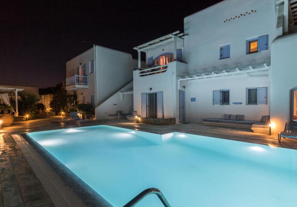 奥诺斯Verano Mykonos Villa的一座游泳池,在晚上在建筑物前