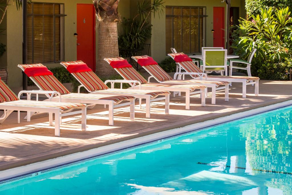 棕榈泉沙漠里维埃拉酒店的一组椅子坐在游泳池旁