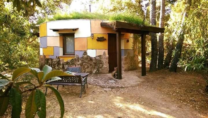 Valverde de la VeraApartamentos Rurales Ecopangea的前面有长凳的小房子