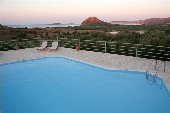 古卡斯特隆Liostasi Country Houses的一个带两把椅子的游泳池,享有山景