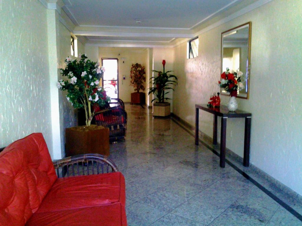 卡波布里奥Cobertura Climatizada, Spa no litoral的客厅配有红色沙发和鲜花