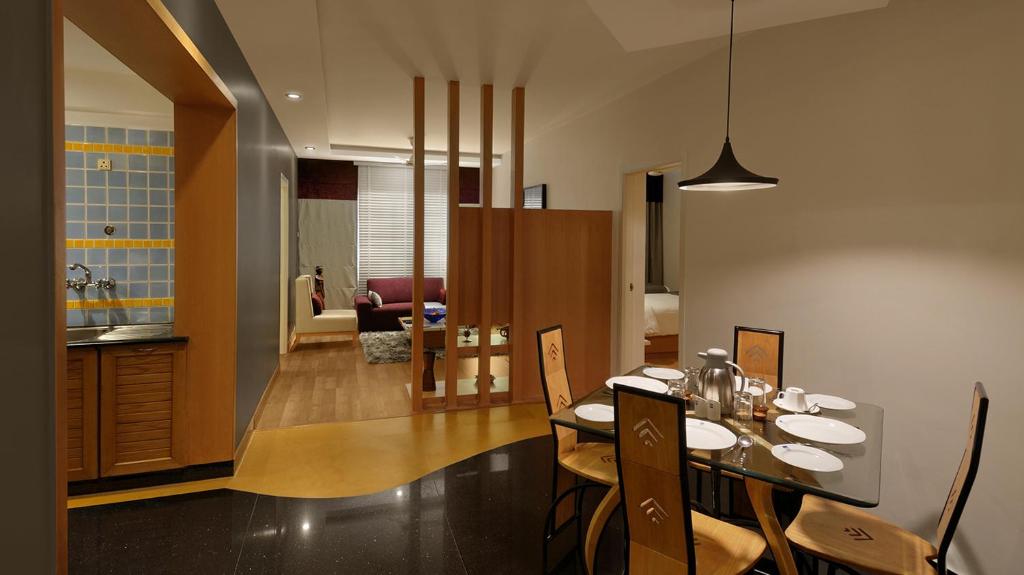 班加罗尔美兰格豪华服务式公寓的用餐室以及带桌椅的厨房。