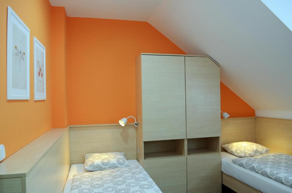 布兰斯科Restaurace Obůrka的小型阁楼卧室设有橙色墙壁