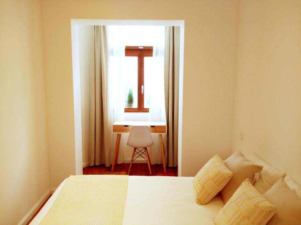 布鲁塞尔德莫特住宿加早餐旅馆的一间卧室配有一张床、一个窗口和一张书桌