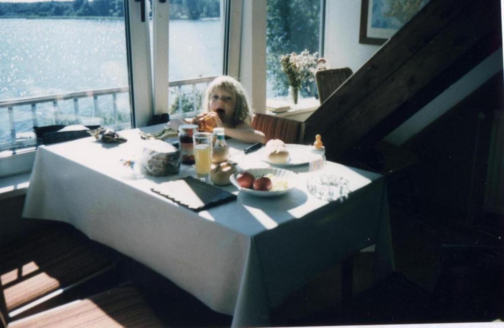 ZarrentinSchaalseeblick的坐在餐桌上吃一盘食物的孩子