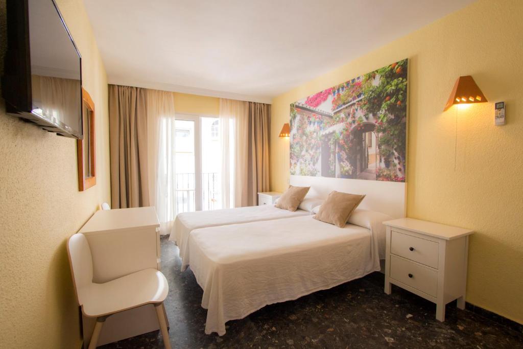 多列毛利诺斯米格尔海滩普拉亚俱乐部酒店的酒店客房,配有两张床和椅子