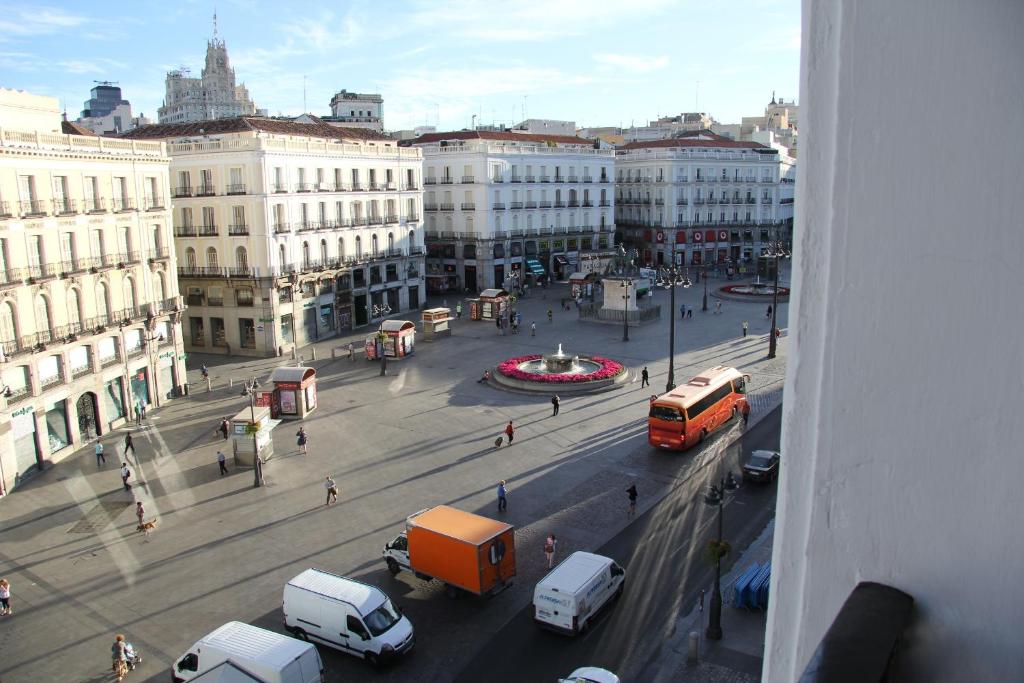 马德里索尔马约尔公寓的享有繁忙的城市街道的景色,街道上设有汽车和巴士