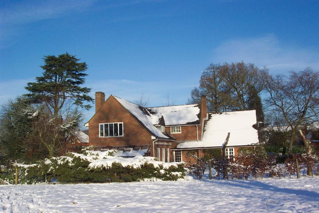 艾尔斯伯里Mayertorne Cottage的一座大砖房,有雪