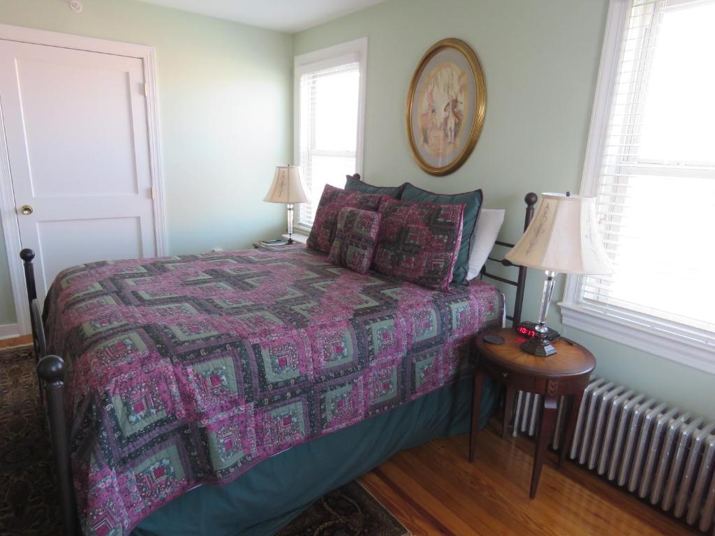 盖茨堡The Swope Manor Bed & Breakfast的一间卧室配有一张带紫色床罩和两盏灯的床。