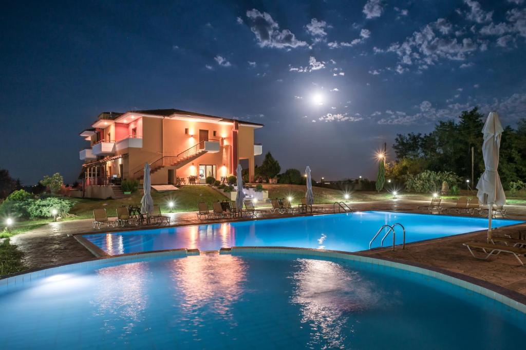 MándraPetrinos Lofos的夜间在房子前面的游泳池