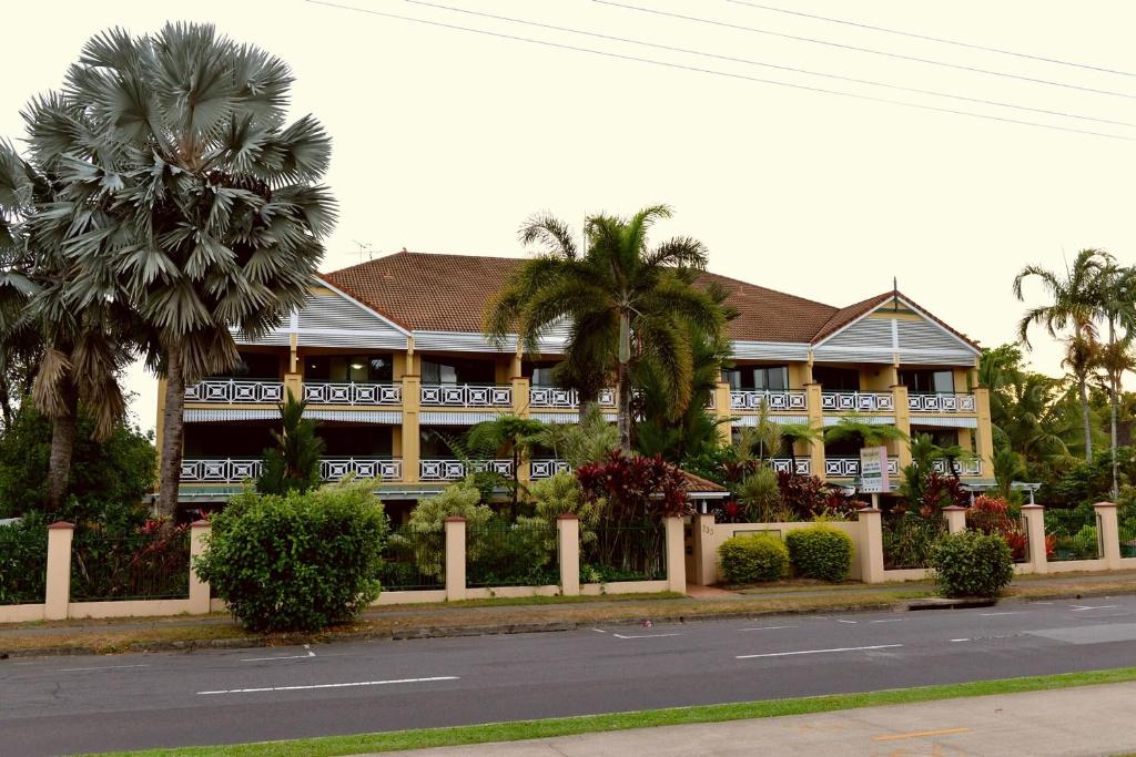 凯恩斯海滨陶乐酒店的一条街道前方有棕榈树的大建筑