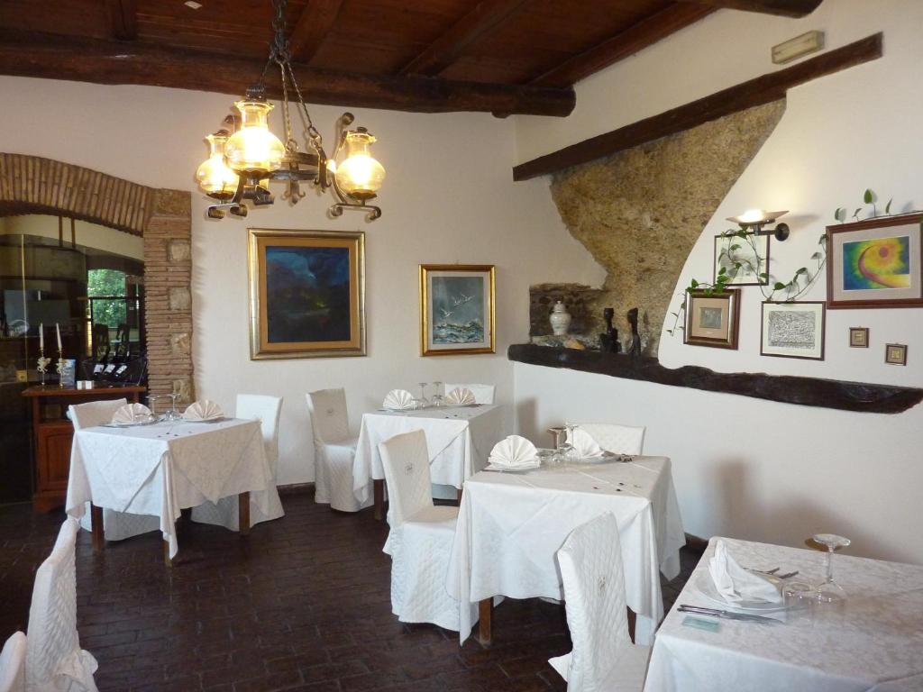 纳尔尼拉罗卡酒店的用餐室配有白色的桌子和白色的椅子