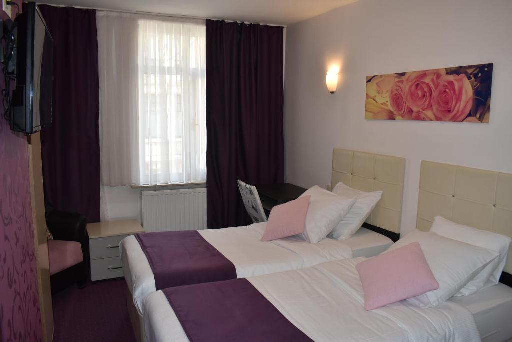 布鲁塞尔魅力贝尔酒店的酒店的客房 - 带2张带粉红色枕头的床