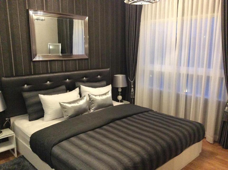 华欣塔斯特豪华公寓的一间卧室配有一张大床和镜子
