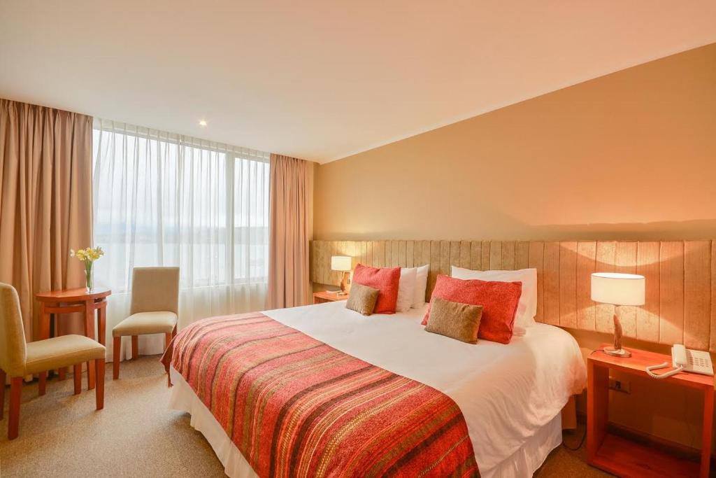 比亚里卡特拉兹套房酒店的酒店客房带一张大床和一把椅子