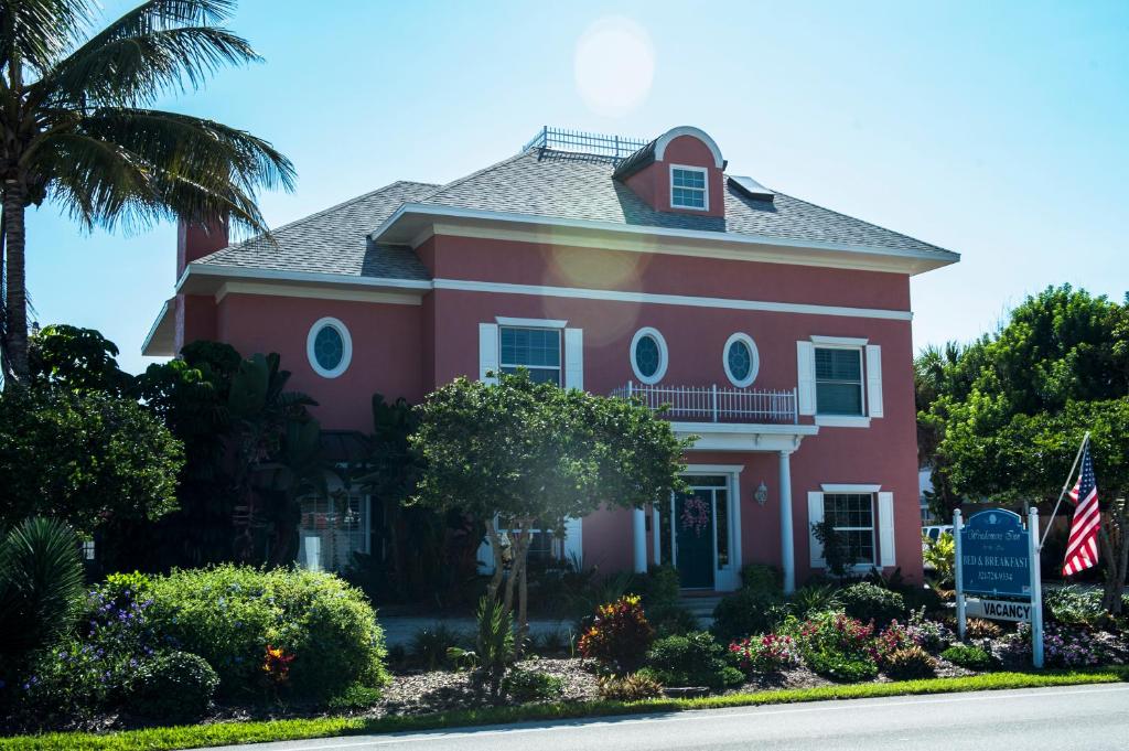 墨尔本温德米尔海滨酒店的前面有旗帜的粉红色房子