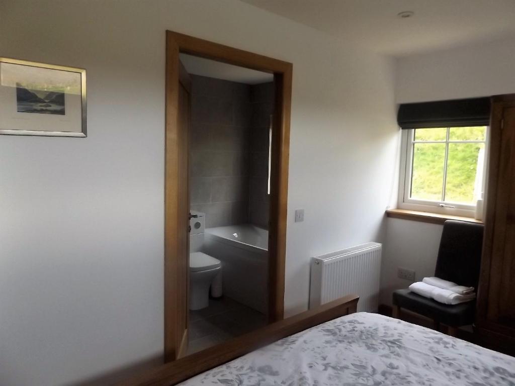 EyreKeistle Cottage的浴室设有床、卫生间和窗户。