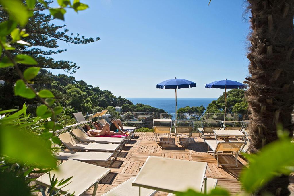 卡普里拉佛洛里迪安娜酒店的海滩上的一排躺椅和遮阳伞