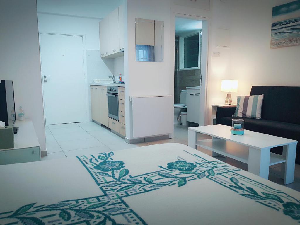 利马索尔Billis Beach Apartment的白色的客厅设有厨房和桌子