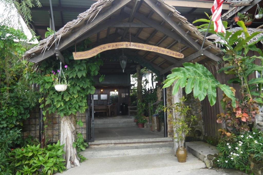 哥打京那巴鲁Kasih Sayang Hill Resort的一座植物繁多的建筑的入口