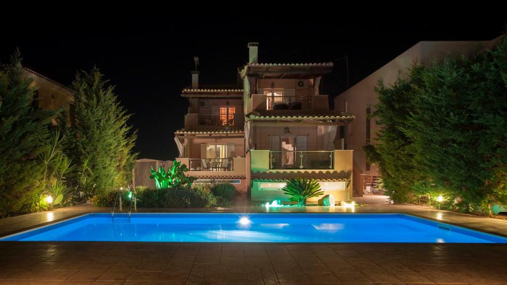 爱琴娜岛Aegina Villa Kalliopi的一座房子,在晚上前设有一个游泳池