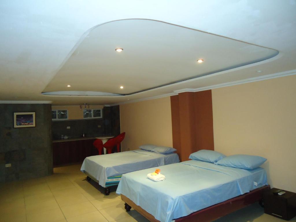 MercedesHostaling Guayaquil Trabajo的酒店客房带两张床和厨房
