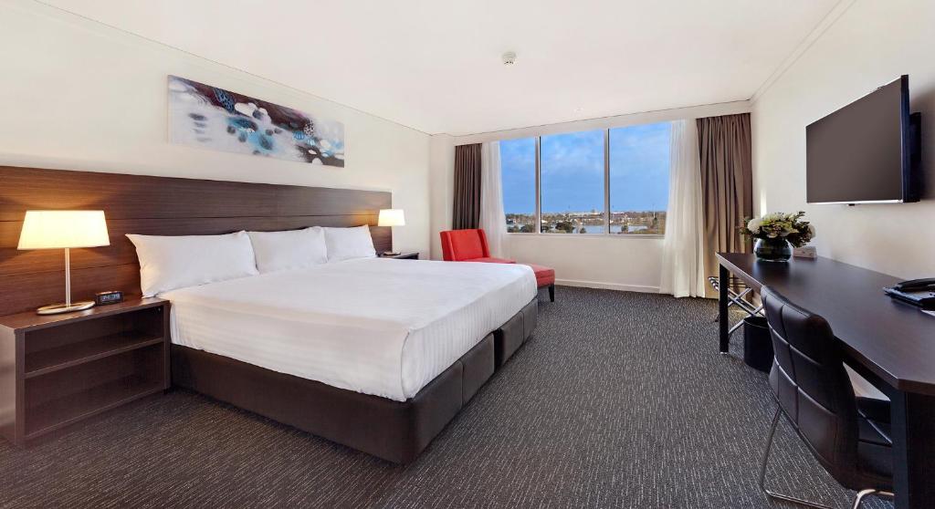 墨尔本墨尔本亚当湾景酒店的配有一张床和一张书桌的酒店客房