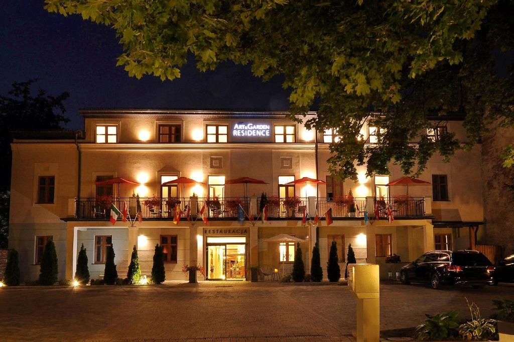 克拉科夫艺术花园住宅酒店的一座在晚上有灯光的建筑