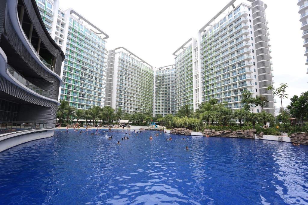 马尼拉茂伊蔚蓝公寓式酒店的一座游泳池,位于一些高楼前