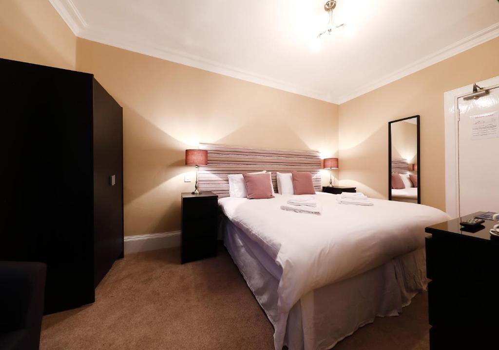 卡诺斯蒂The Station Hotel的卧室配有一张带白色床单和枕头的大床。