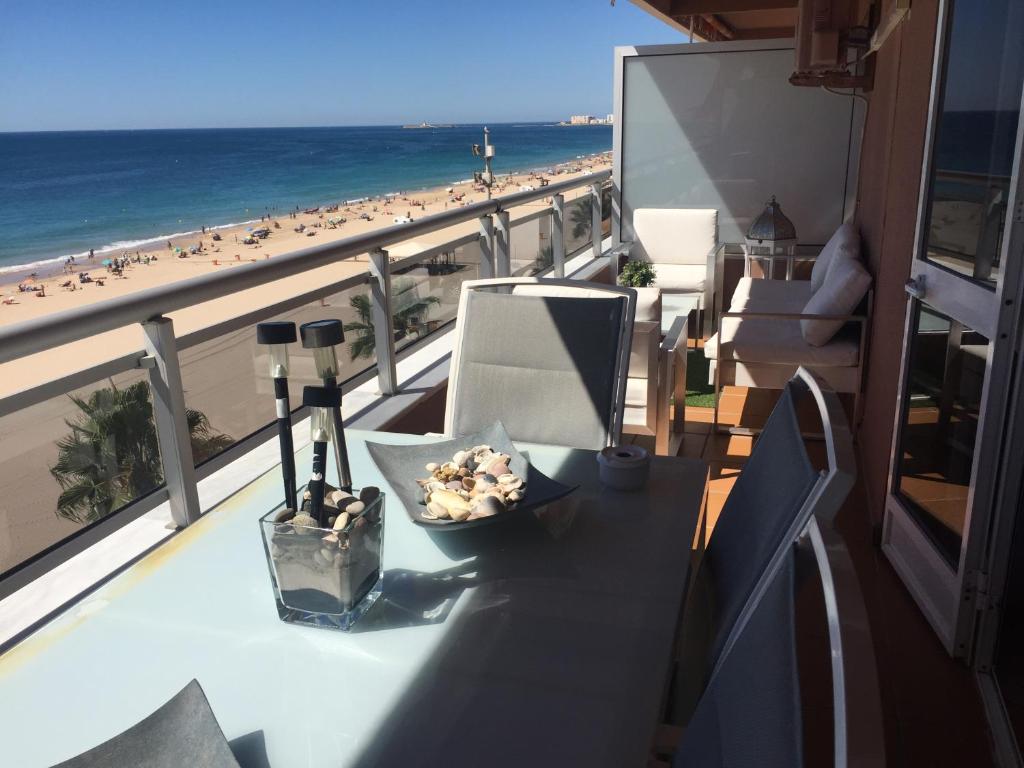 加的斯Luxury Oceanfront triplex in Cadiz的海滩景阳台桌子