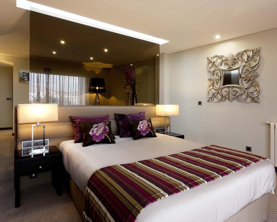 庞巴尔卡达尔酒店的一间卧室配有一张带紫色枕头的大床