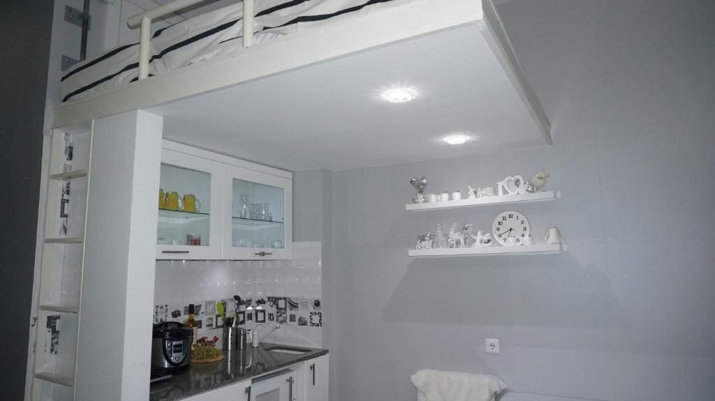 古多里White Tiger in New Gudauri II的一间带白色橱柜和高架床的厨房