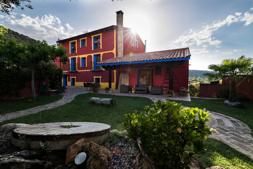 CarenasValle Del Río Piedra的一座色彩缤纷的房子,前面有一个花园