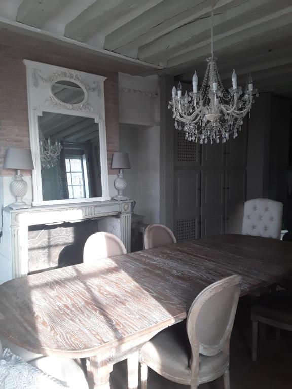 阿姆博斯La Capitainerie的一间带桌椅和吊灯的用餐室