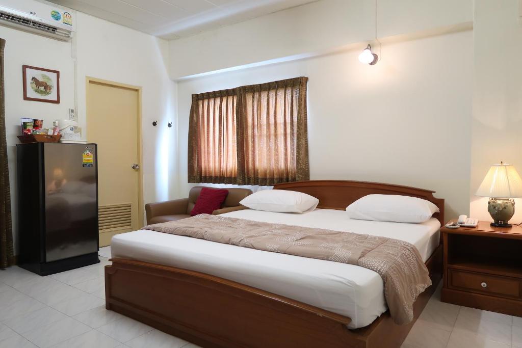曼谷Phawana Sweet Hotel的一间卧室配有一张大床和电视