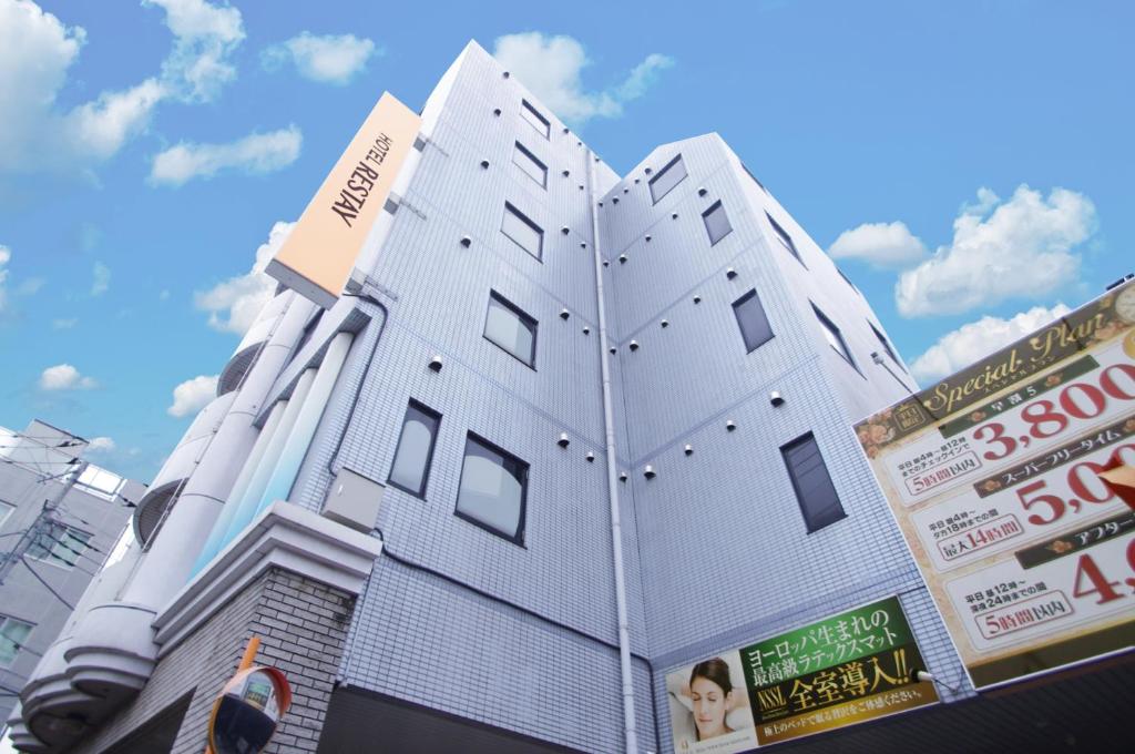 府中市Restay Fuchu (Adult Only)的白色的建筑,窗户在建筑的一侧