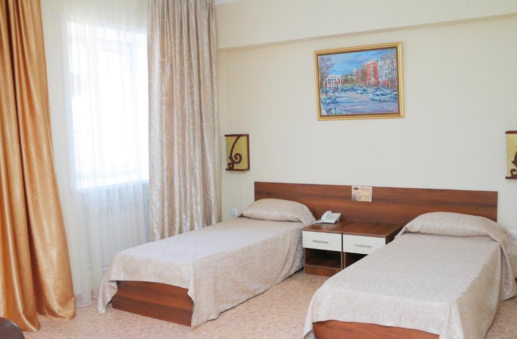 卡拉甘达祖穆拉特酒店的酒店客房设有两张床和窗户。