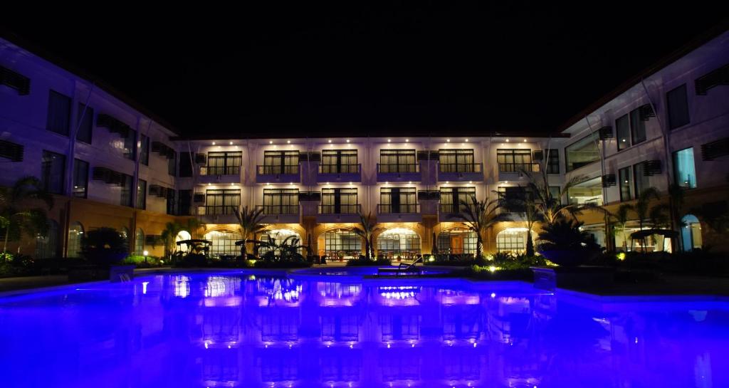 武端市欧厄齐斯酒店的一座建筑,在晚上前方有一个游泳池