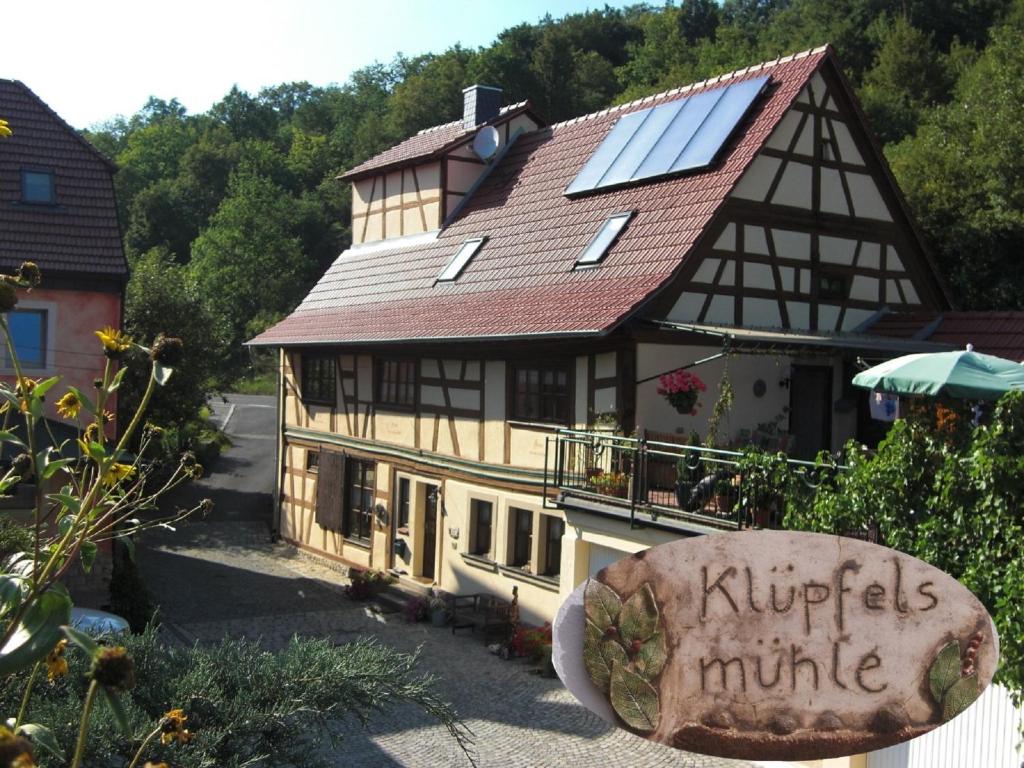 SchonungenFerienwohnung Klüpfelsmühle的一座房子,上面有太阳能屋顶,上面有标志