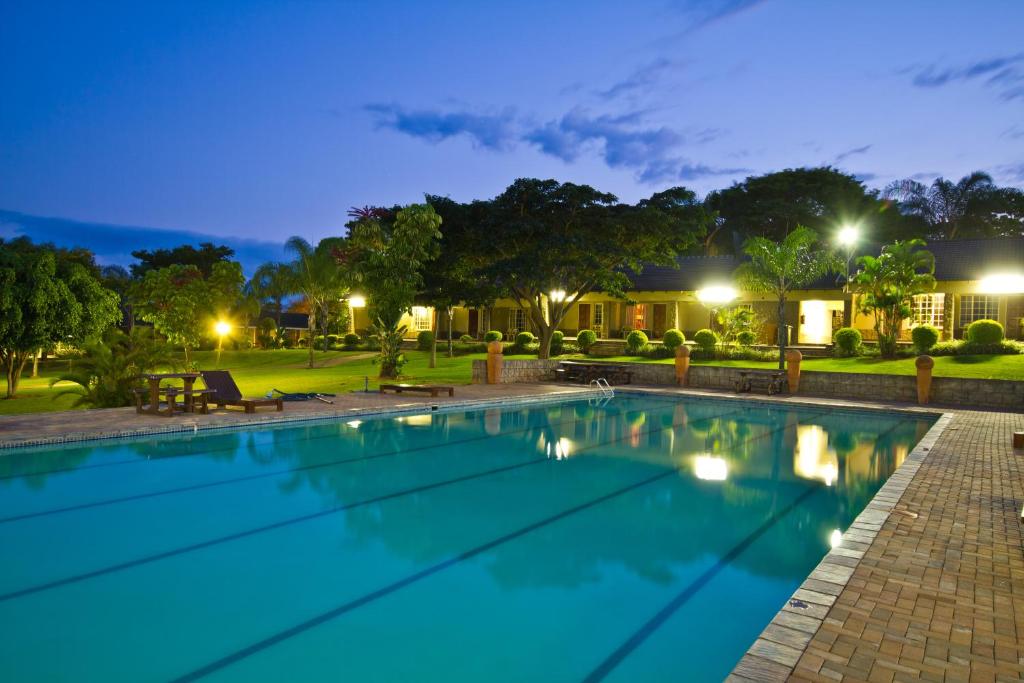白河ANEW Resort White River Mbombela的夜间在度假村的游泳池